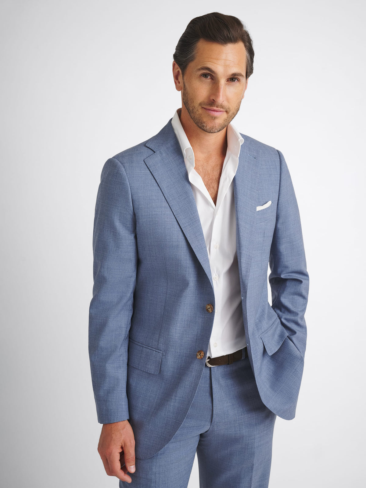 Faded Blue  Man wearing a light blue suit with a white shirt on a plain background
